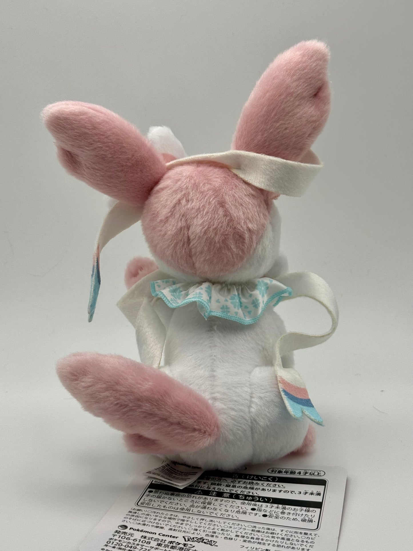 Eevolvd Sylveon Plush med vinkandes och sittandes pose sedd fran bakre sidan direkt fran Pokemon Center Japan