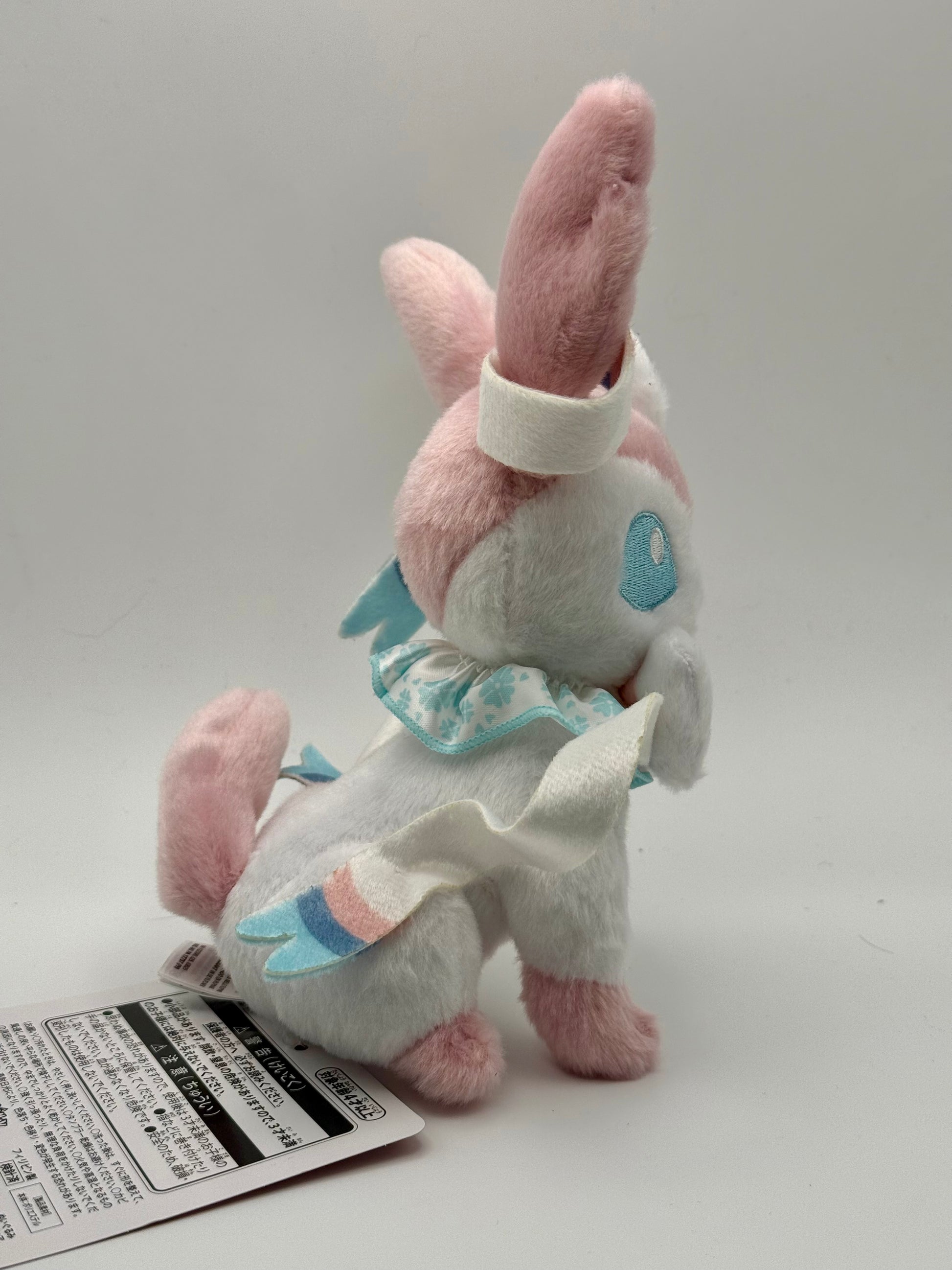 Eevolvd Sylveon Plush med vinkandes och sittandes pose sedd fran hoger sida direkt fran Pokemon Center Japan