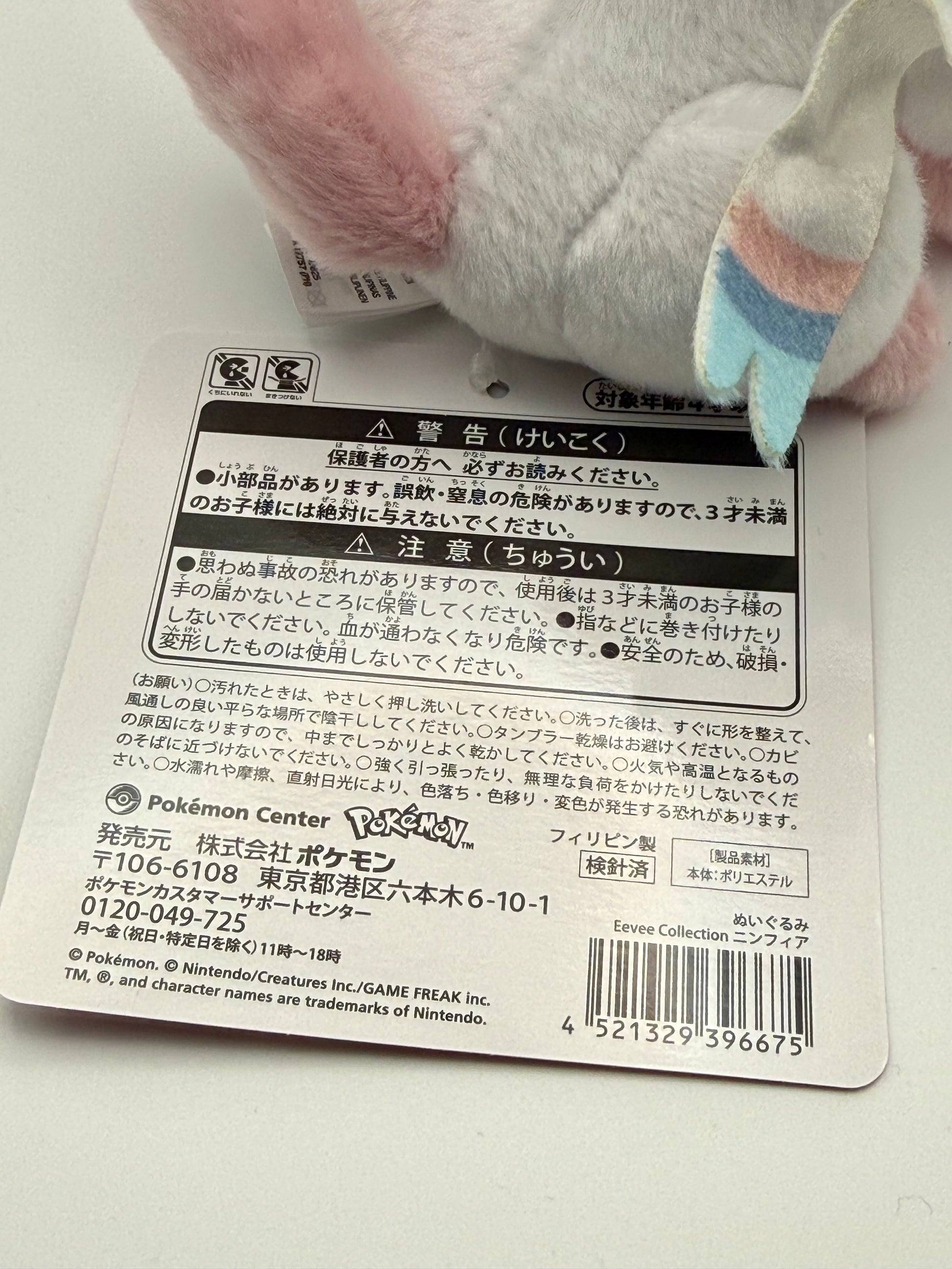 Eevolvd Sylveon Plush med vinkandes och sittandes pose sedd med sin tag pa baksidan direkt fran Pokemon Center Japan