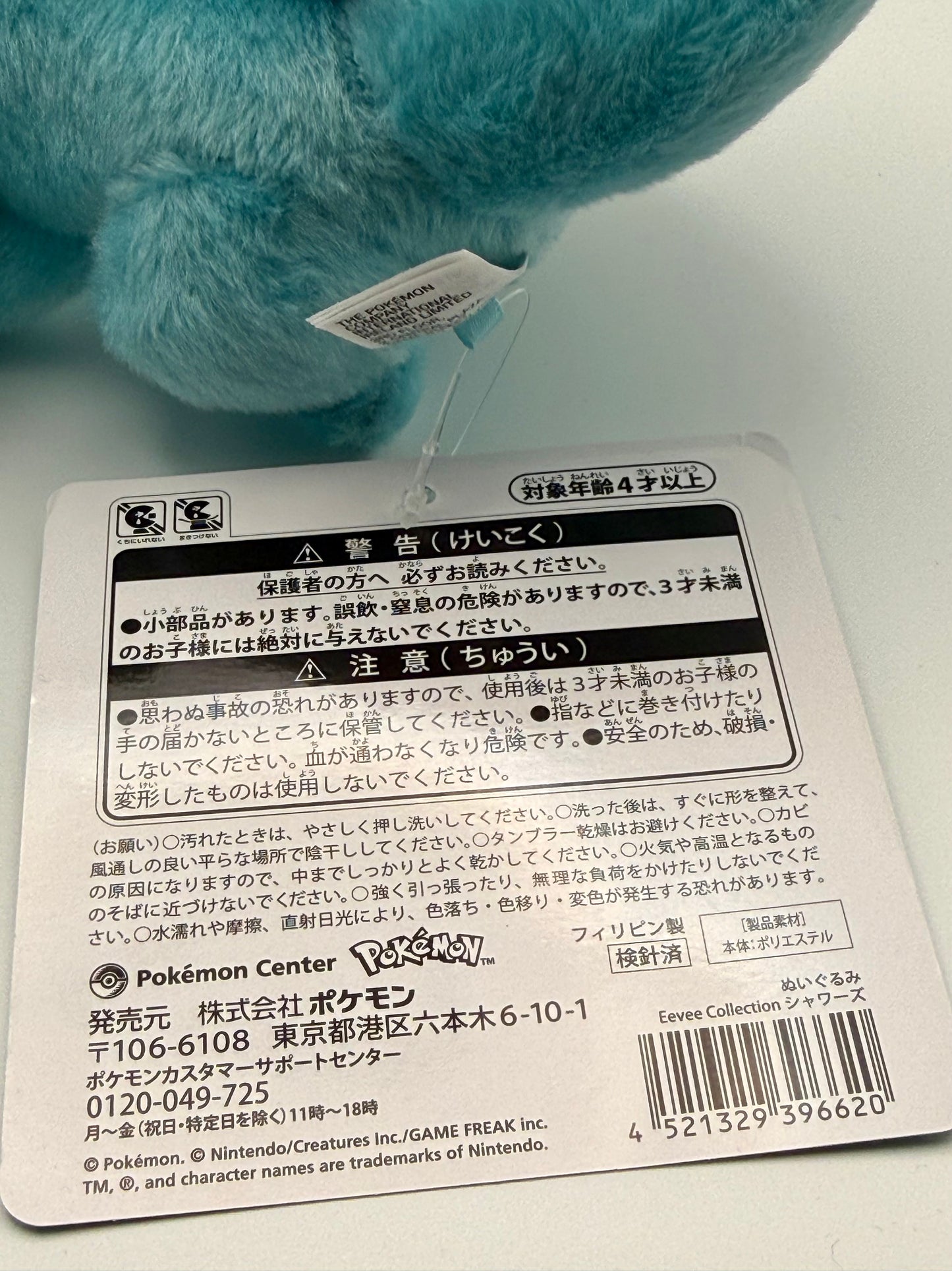 Eevolvd Vaporeon Plush med vinkande tass och sittandes med ett leende med sin tag baksida direkt fran Pokemon Center Japan