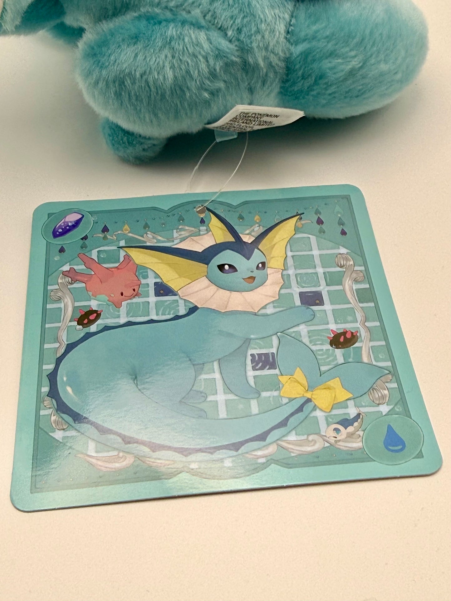 Eevolvd Vaporeon Plush med vinkande tass och sittandes med ett leende med sin tag framsida direkt fran Pokemon Center Japan